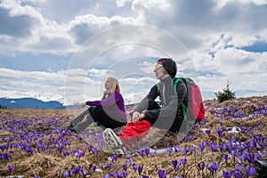 Women with backpacks enjoying saffron blooming at early spring