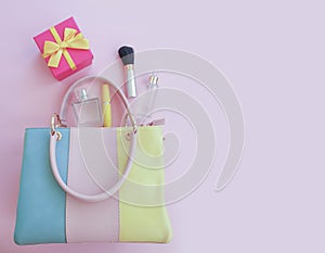 Women bag, cosmetics mascara   composition  shopping   glamour    on a colored background