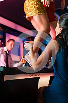 Women in bar or club are dancing on the table
