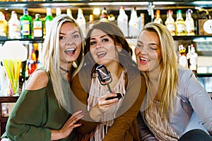 Women in bar singing karaoke