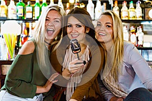 Women in bar singing karaoke