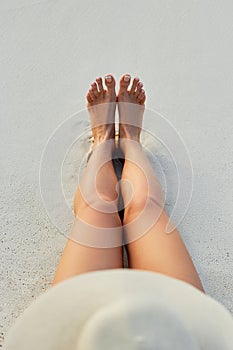 Women Beautiful Sexy Legs on the Beach. Skin care and Protection Sun. Spa Concep.