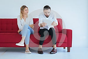 Woman bored and disregard to man sitting on couch in living room together,Family issues concept photo