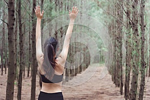 Women breathe fresh air in middle of pinewood forest while exercising. Workouts and Lifestyles concept. Happy life and Healthcare