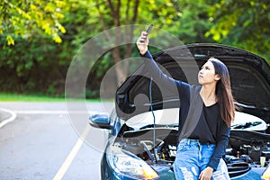 Women and broke down car on the road and he find signal mobile phone