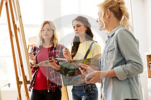 Women with brushes painting at art school