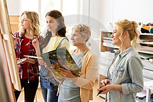 Women with brushes painting at art school