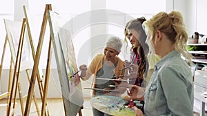 Women with brushes painting at art school