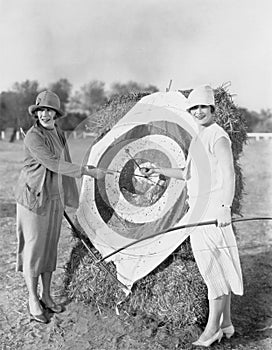 Women with bulls eye in archery target photo