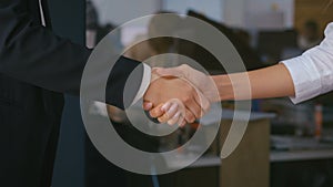 Women business partners handshaking, close-up.