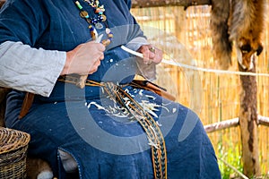 Women carpenter wearing rural clothing and carving a wooden sti