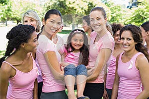 Women carrying girl during breast cancer awareness