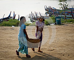 Women carrying goods on rural road in Mandalay, Myanmar