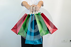 Women are carrying various colorful shopping bags. Close-up photo
