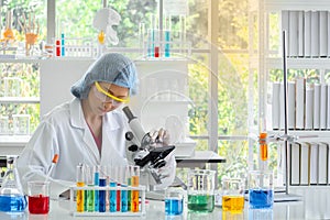 Women chemist using microscope