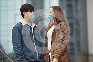 A woman and Chinese man are wearing protective masks photo