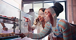 Women, choice and buy donuts in bakery by counter, hands and select danish by glass display. Junk food, friends and