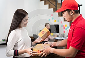 Women are choosing and receiving parcel boxes from the courier staf. Courier Staff delivers a parcel to a woman who orders from