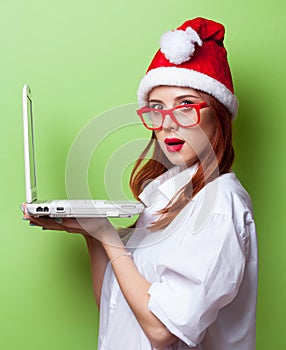 Women in christmas hat with white laptop computer