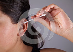 Women clean the ear with cotton swab