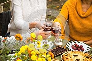 Women clink glasses with wine at autumn family dinner. photo