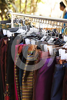 Women clothes made from Thai eastern silk hanging on rack