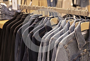 Women clothing - fall winter collection. denim jackets on hangers in the store. the concept of conscious consumption and recycling