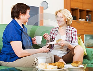 Women colleagues drinking coffe and chatting during coffee break