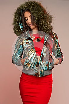 Women in colourful jacket with triangle, black necklace