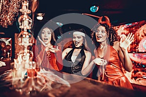 Women in Costumes Looking at Flaming Cocktail