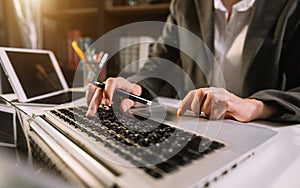 Women counting coins on calculator taking from the piggy bank. hand holding pen working on calculator to calculate on desk