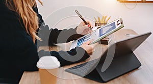 Women counting coins on calculator taking from the piggy bank. hand holding pen working on calculator to calculate on desk about