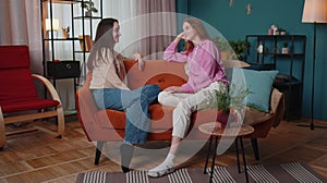 Women couple family secrets gossip, conversation, news rumors chatting talking together at home sofa