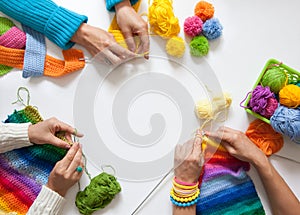 Women crochet and knitting from colored yarn. View from above.