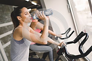 Women cycling in gym during fitness class