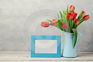 Women day concept, 8th of March with tulip flowers and photo frame