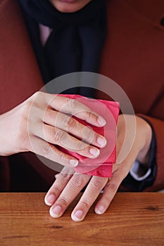 women disinfecting his hands with a wet wipe.