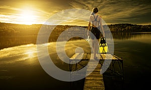 Women diver in swimsuit, on the edge of the pier