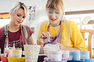 Women in DIY workshop coloring and decorating their own ceramic