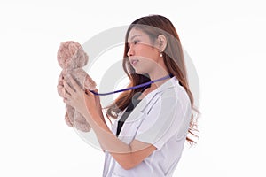 Women doctor uses sthethoscope to detect teddy bear photo