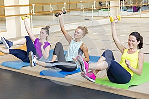 Women doing dumbbell exercises at a group workout in a fitness room