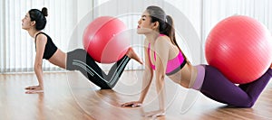 Women doing exercise with fit ball in gym class