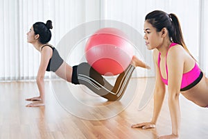 Women doing exercise with fit ball in gym class