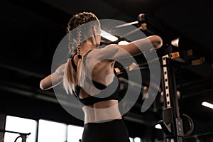 Women doing pull ups training arms with trx fitness straps in the gym. Upper body training. Back view.