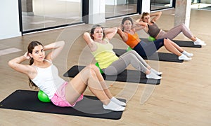 Women doing spine twist with pilates balls