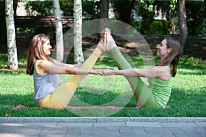 Women doing yoga outdoors in the park.