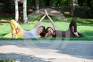 Women doing yoga outdoors in the park.