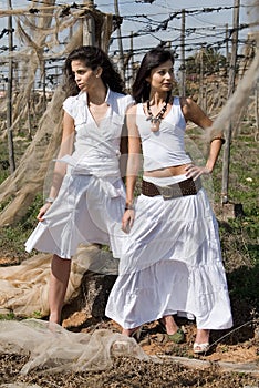 Women dressed in white in a wasteland of abandoned crops