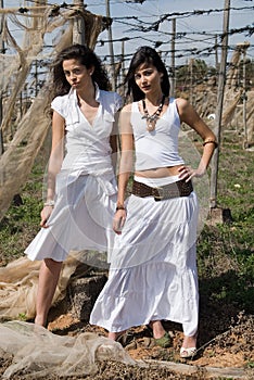 Women dressed in white in a wasteland of abandoned crops