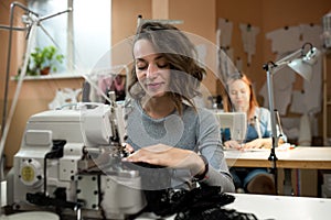 Women dressmakers work in the workshop on sewing machines